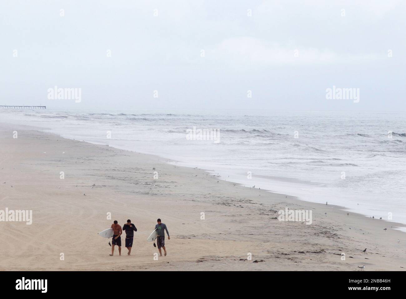 With mandatory evacuations for visitors and residents in place before the arrival of Hurricane Irene, a beach is largely deserted as surfers walk away from the water in Nags Head, N.C., Friday, Aug. 26, 2011 on North Carolina's Outer Banks. (AP Photo/Charles Dharapak) Banque D'Images