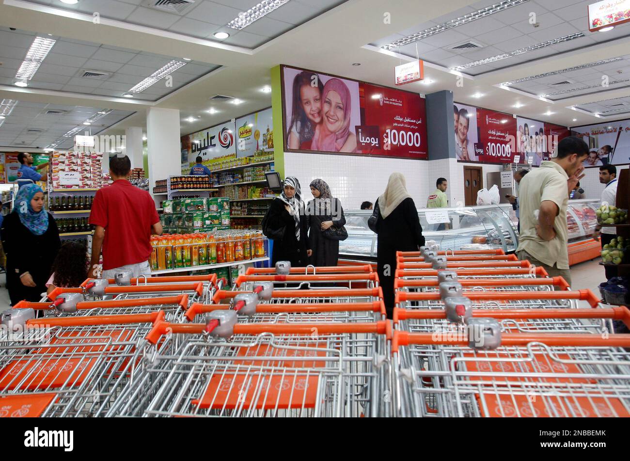 In this picture taken Tuesday, Aug. 16, 2011 Palestinians shop at the new al-Andulusia mall in Gaza City. An abrupt flurry of construction is suddenly allowing a tiny middle class to flaunt its wealth in the impoverished Gaza Strip, fueling perhaps the most acrimonious grassroots resentment yet toward the ruling Hamas movement. (AP Photo/Hatem Moussa) Banque D'Images