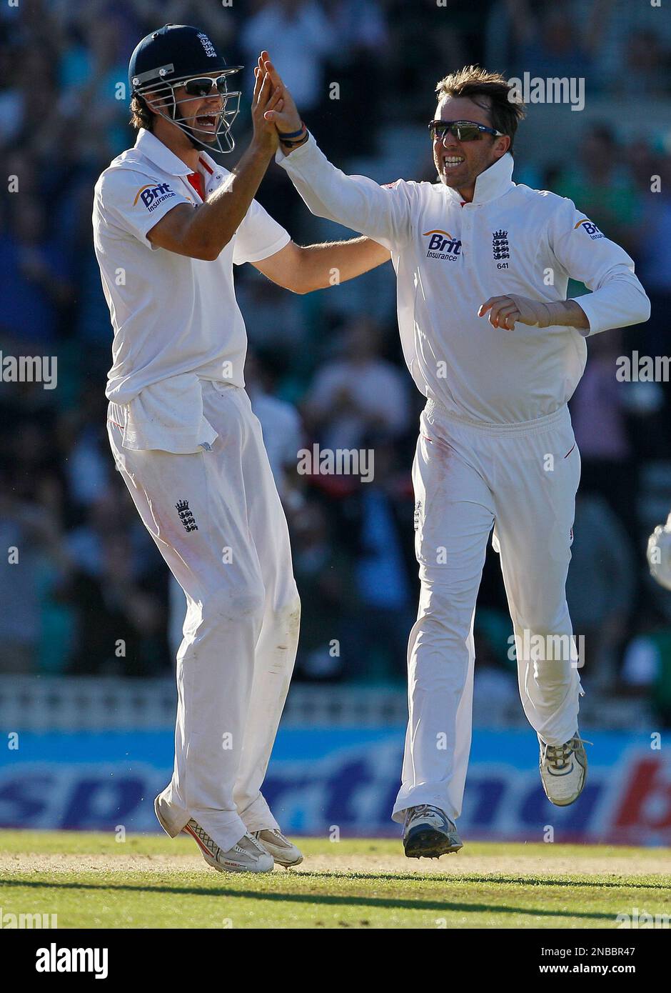 England's Graeme Swann, right, celebrates with Alastair Cook after taking the wicket of India's Sachin Tendulkar in their fourth Test match, at The Oval cricket ground in London, Saturday, Aug. 20, 2011. (AP Photo/Kirsty Wigglesworth) Banque D'Images