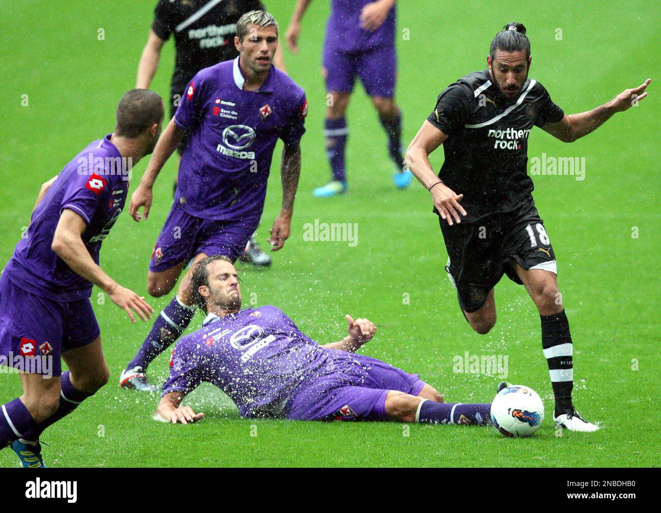 Newcastle United's Jonas Gutierrez, right, vies for the ball with Fiorentina's Alberto Gilardino, bottom, during their pre season friendly soccer match at St James' Park, Newcastle, England, Saturday, Aug 6, 2011. (AP Photo/Scott Heppell) NO INTERNET/MOBILE USAGE WITHOUT FOOTBALL ASSOCIATION PREMIER LEAGUE(FAPL)LICENCE. CALL +44 (0) 20 7864 9121 or EMAIL info@football-dataco.com FOR DETAILS Banque D'Images