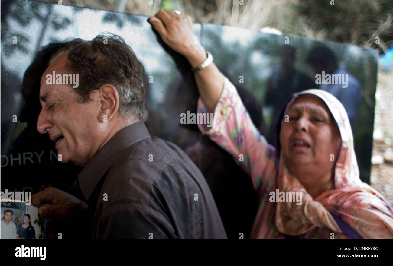 Family members of a last year's plane crash, mourn their deaths during their visit to a monument built near the site of crash, in Islamabad, Pakistan on Thursday, July 28, 2011. Family members and friends gathered to pray for the victims of a plane crash which killed 150 people on board. (AP Photo/B.K.Bangash) Banque D'Images
