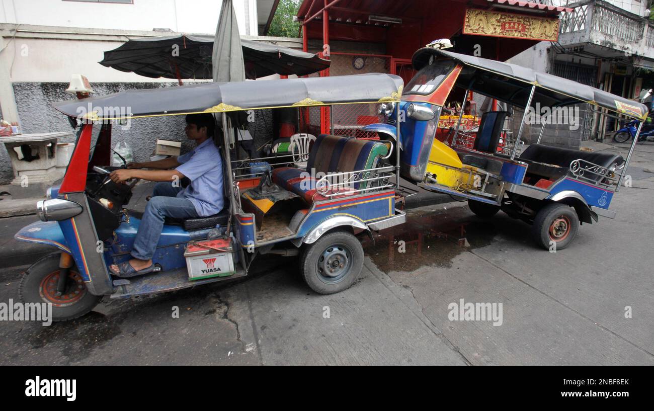 Tuk-Tuk or auto rickshaw driver haul another Tuk-Tuk to a garage in Bangkok, Thailand, Tuesday, July 26, 2011. (AP Photo/Sakchai Lalit) Banque D'Images