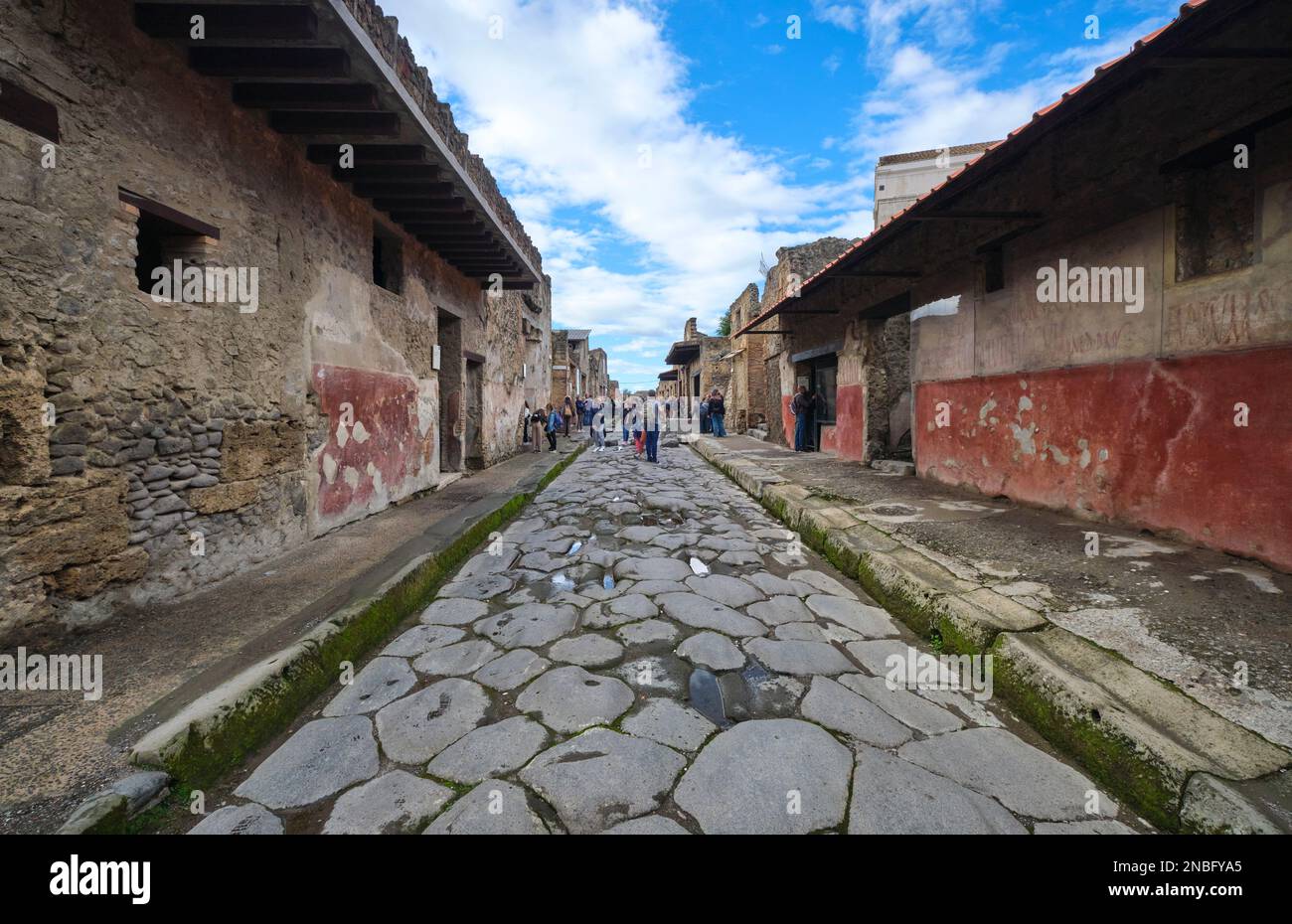 Une vue en perspective, en descendant la rue via dell' Abbondanza avec divers touristes. Au parc archéologique de Pompéi, près de Naples, en Italie. Banque D'Images