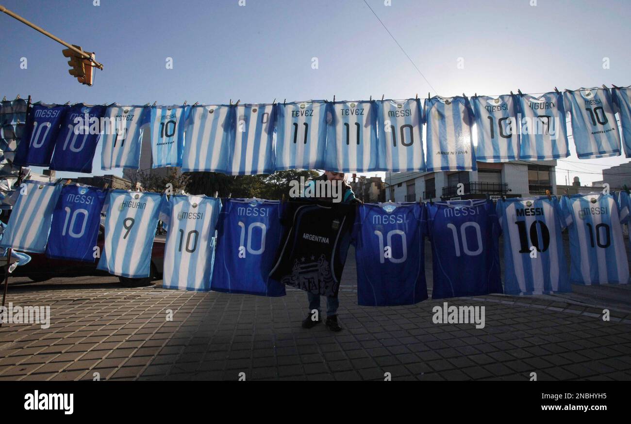 A woman selling replicas of the Argentina national soccer team jerseys, prepares for the day's customers in Santa Fe, Argentina, Monday July 4, 2011. The South American country is hosting the 2011 Copa America from July 1-24. Argentina coach Sergio Batista is likely to make only one change for the match against Colombia at the Copa America on Wednesday as he seeks improvement from the 1-1 draw with Bolivia in the opener. (AP Photo/Fernando Vergara) Banque D'Images