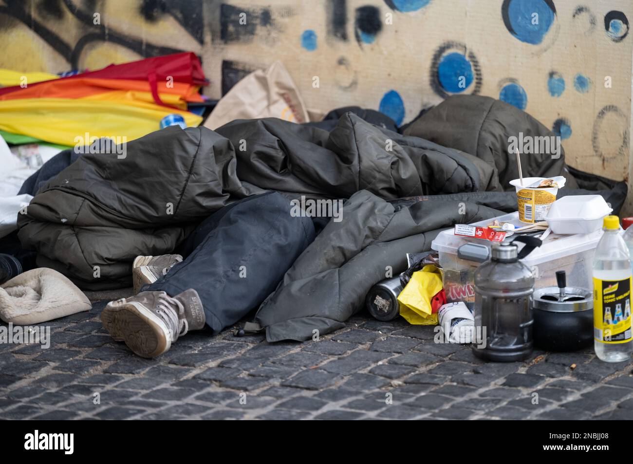 Stuttgart, Allemagne. 14th févr. 2023. Une personne se trouve sous un sac de couchage dans le centre-ville. La Ligue des organisations de protection sociale indépendantes présente son enquête annuelle sur le soutien aux personnes dans l'exclusion sociale et les besoins en matière de logement lors d'une conférence de presse. Credit: Marijan Murat/dpa/Alamy Live News Banque D'Images