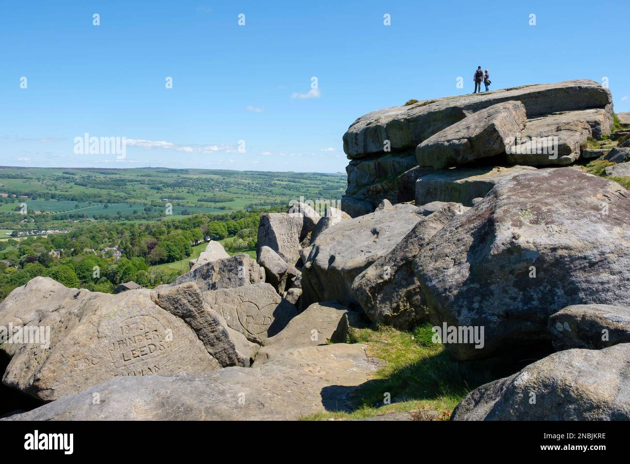 Deux personnes ont vue sur Wharfedale depuis Cow and Calf Rocks, Ilkley Moor, Rombalds Moor, West Yorkshire, Royaume-Uni Banque D'Images