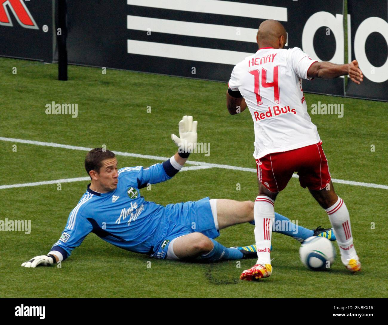 Portland Timbers goalkeeper Troy Perkins, left, slides in to block an attempt by New York Red Bulls forwardDwayne De Rosario to pass the ball into the goal mouth during the first half of their MLS soccer game in Portland, Ore., Sunday, June, 19, 2011. (AP Photo/Don Ryan) Banque D'Images