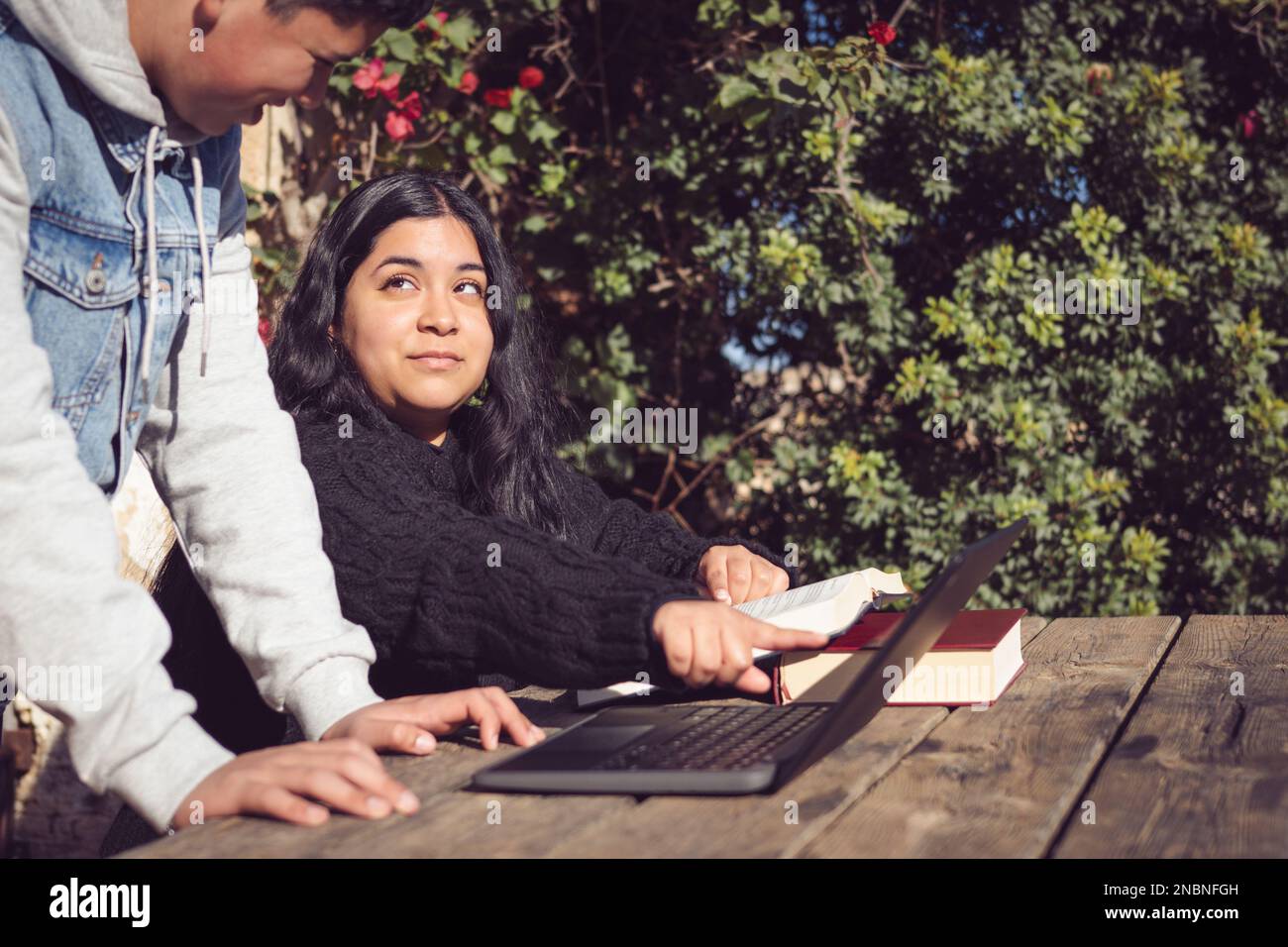 deux jeunes hommes étudient à l'extérieur de l'école avec des ordinateurs portables Banque D'Images