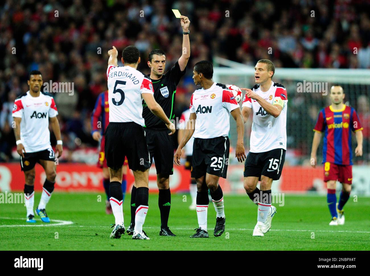 Referee Viktor Kassai of Hungary shows a yellow card as Manchester United players protest during their Champions League final soccer match against Barcelona at Wembley Stadium, London, Saturday, May 28, 2011. (AP Photo/Manu Fernandez) Banque D'Images