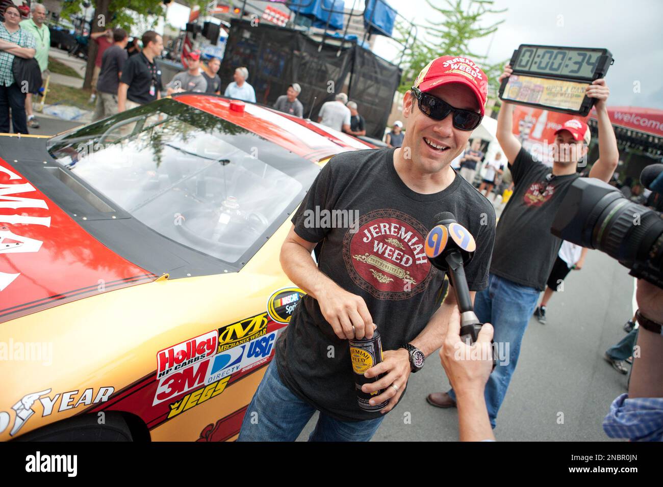NASCAR's Matt Kenseth, driver of the No. 17 Jeremiah Weed Ford, gives an interview after extreme athlete Rendy DeLaCruz (not pictured) pulled Kenseth 100 feet in 26 seconds at an event at Speed Street on Friday, May 27, 2011 in Charlotte, NC. Jeremiah Weed Premium Malt Beverages also distributed pre-paid taxi vouchers to legal drinking age consumers to encourage responsible drinking. Jason E. Miczek / AP Images for Jeremiah Weed Banque D'Images