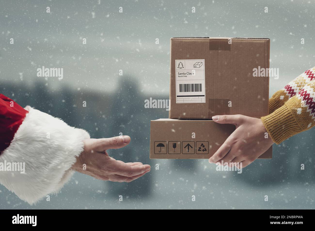 Femme donnant des boîtes de livraison avec des cadeaux de Noël au Père Noël, livraison et concept d'expédition Banque D'Images