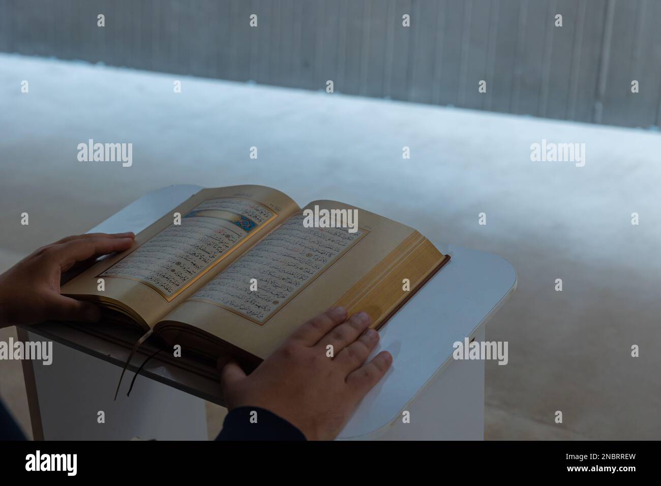 La Sainte Coran sur le lecterne et un homme musulman lisant le Saint Coran. Ramadan ou photo d'arrière-plan islamique avec espace de copie pour les textes. Istanbul Turkiye - 11 Banque D'Images