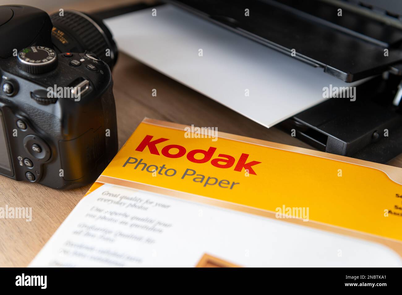 Londres. ROYAUME-UNI-02.12.2023. Un paquet de papier photo Kadak sur un bureau à côté d'une imprimante et d'un appareil photo. Banque D'Images