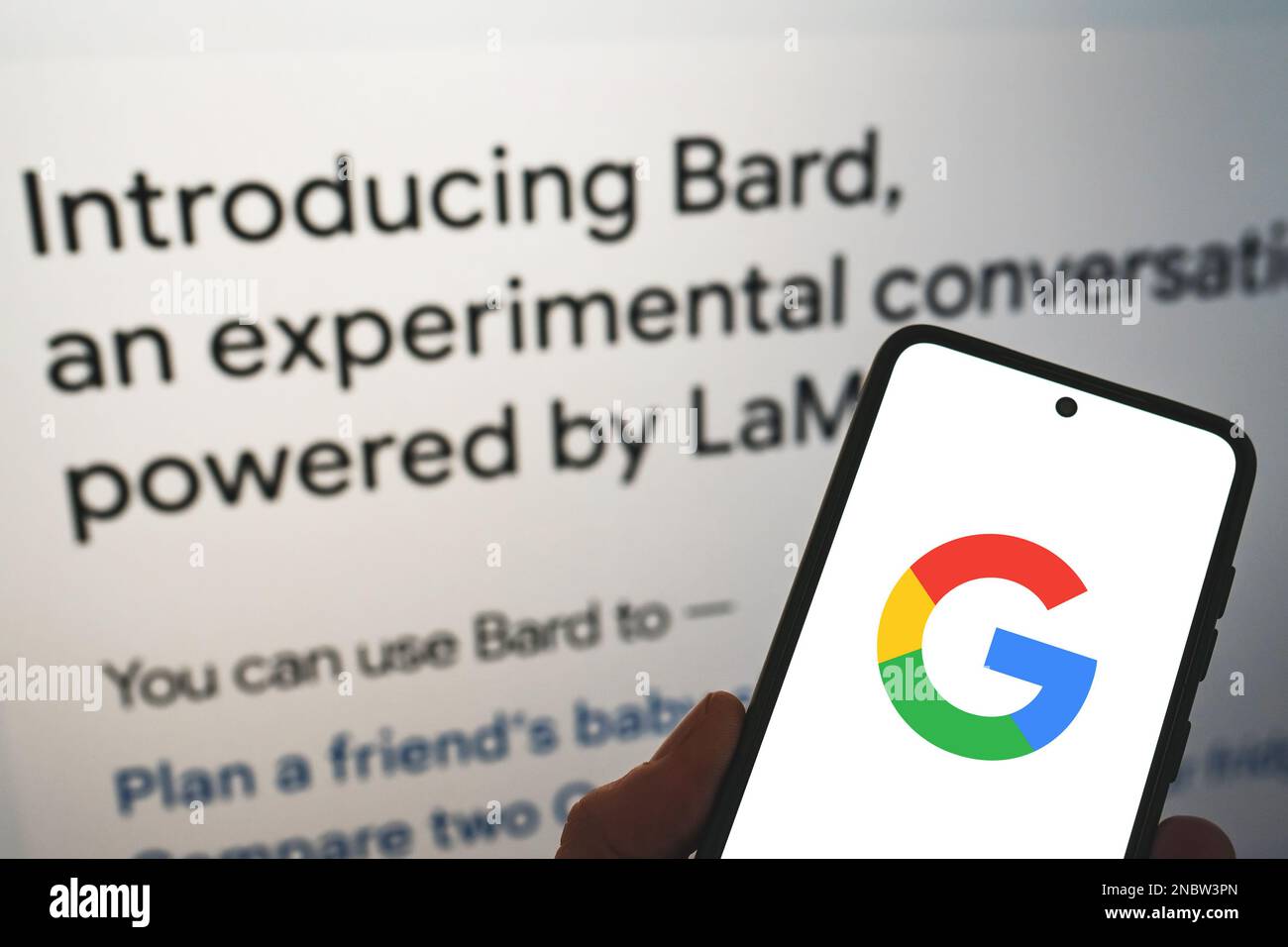 Google lance Bard ai. Logo Google sur le téléphone à portée de main avec les informations de libération en arrière-plan. Google Bard ai contre OpenAI ChatGPT. Varsovie, Pologne - 8 février 2023. Banque D'Images