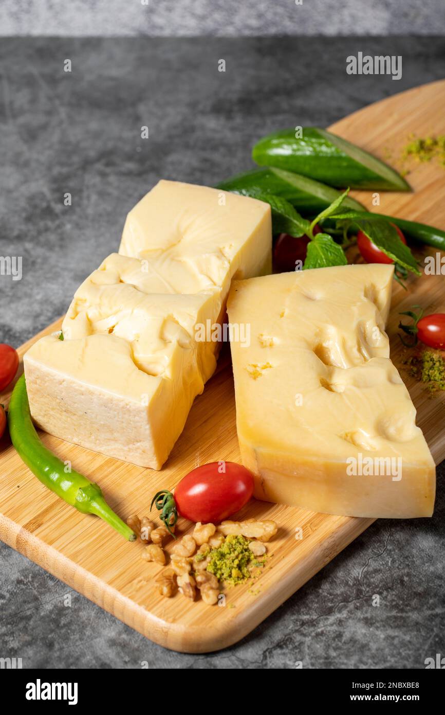 Fromage Gruyère. Morceau de fromage Gruyere sur planche à découper en bois. Collection de fromages Banque D'Images