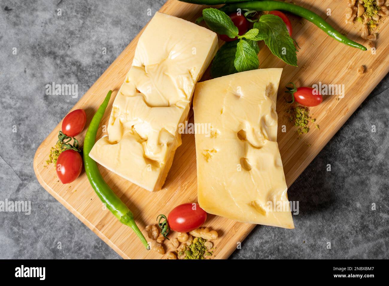 Fromage Gruyère. Morceau de fromage Gruyere sur planche à découper en bois. Collection de fromages. Vue de dessus Banque D'Images