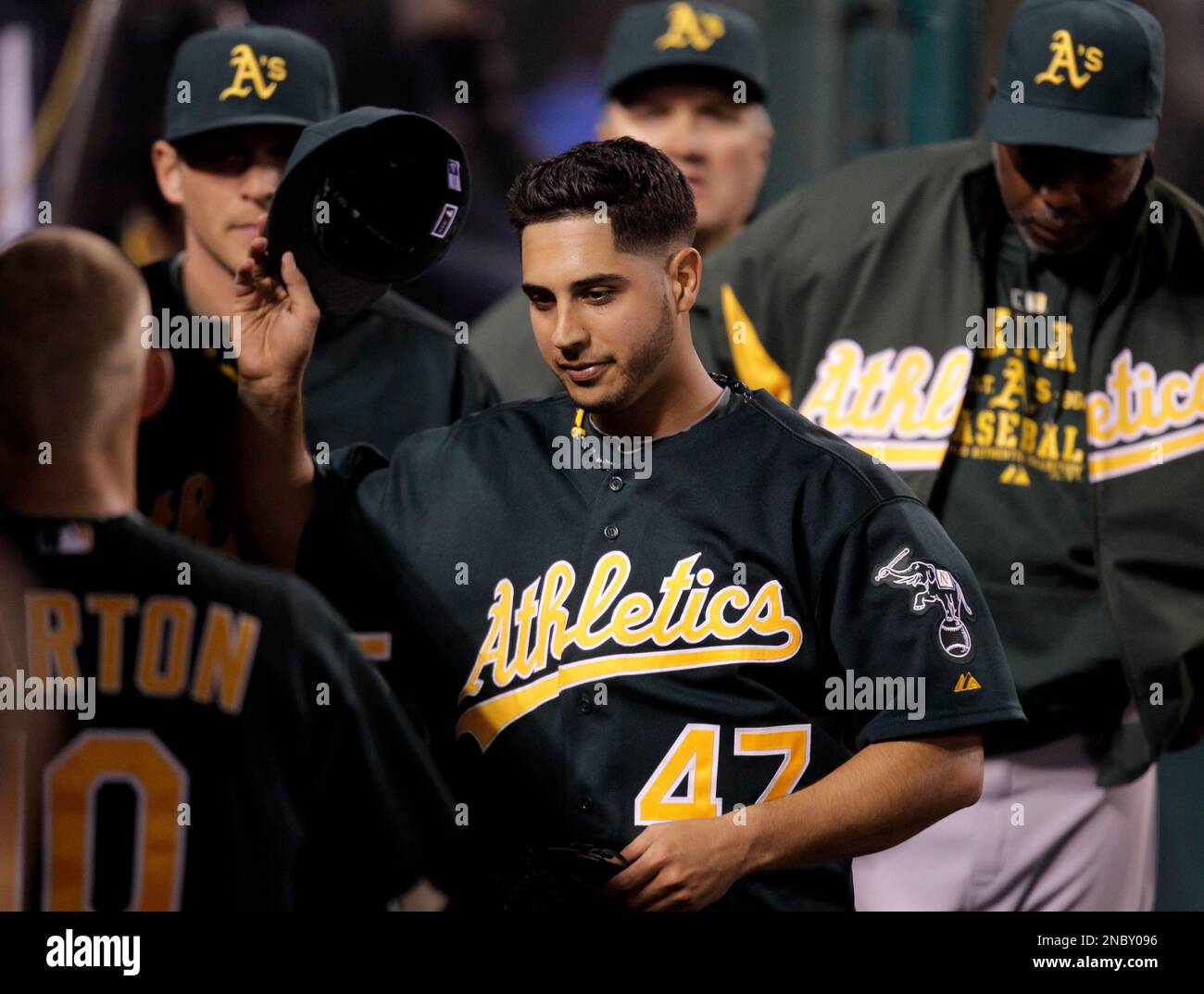 Oakland Athletics starting pitcher Gio Gonzalez, center, takes off his hat in the dugout in the fifth inning of a baseball game against the Los Angeles Angels in Anaheim, Calif., Monday, April 25, 2011. (AP Photo/Jae C. Hong) Banque D'Images