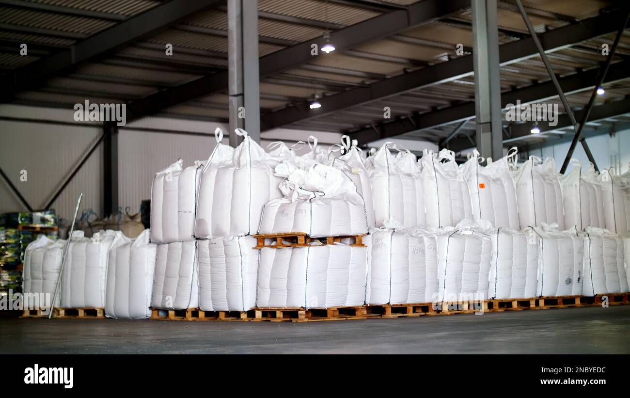 grands sacs pleins de produits céréaliers en stock. Les sacs sont empilés en rangées, entrepôt industriel. Photo de haute qualité Banque D'Images