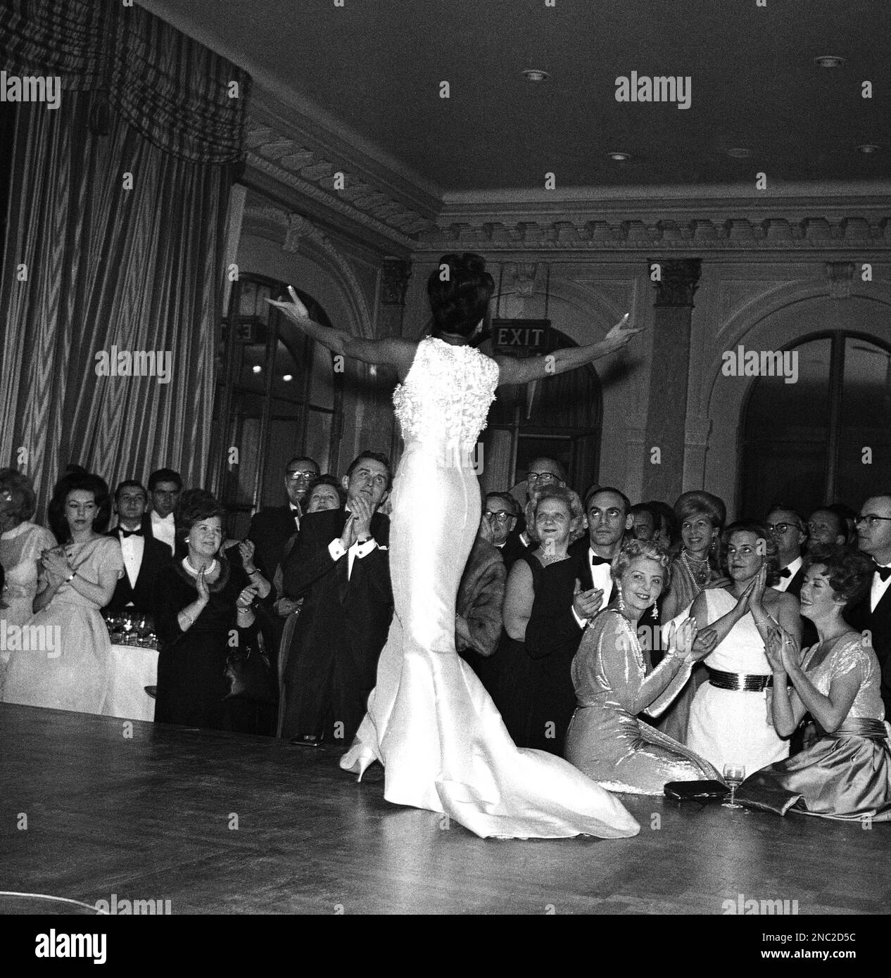 Singer Shirley Bassey has the audience clapping along as she entertains guests to a party at London’s Savoy Hotel on Nov. 24, 1962. The party was to celebrate the start of the eleventh year of consecutive showing of Agatha Christie’s play The Mousetrap at the Ambassadors Theatre. (AP Photo/Bob Dear) Banque D'Images