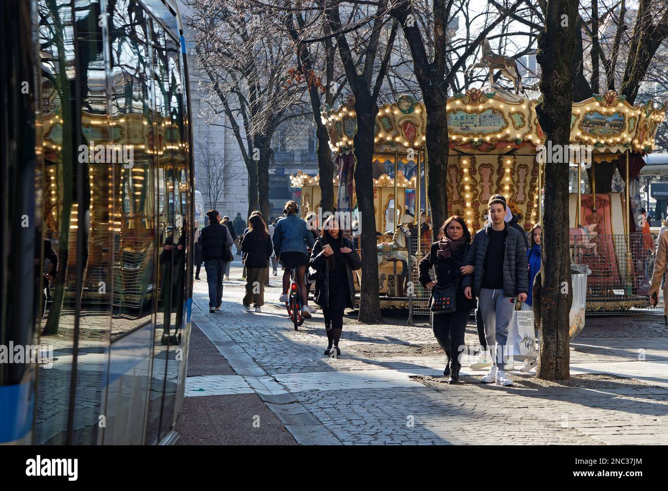 GRENOBLE, FRANCE, 8 février 2023 : le Merry-Go-round se reflète sur les fenêtres du tramway lors d'une journée de forte affluence dans le centre-ville. Banque D'Images