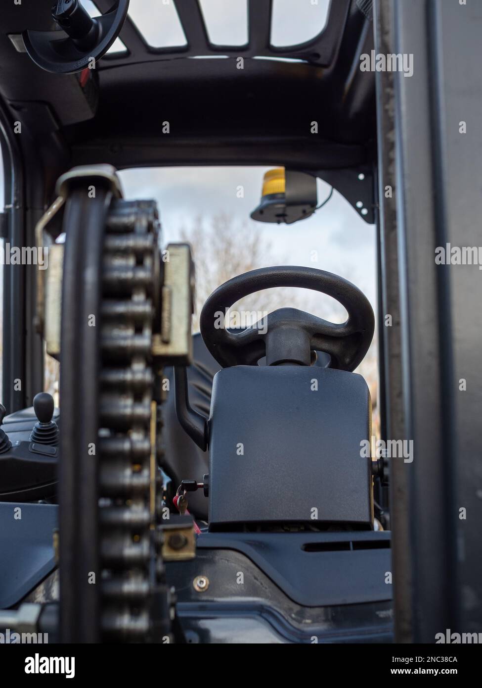 gros plan de la chaîne de levage sur un chariot élévateur avec commandes de direction derrière Banque D'Images