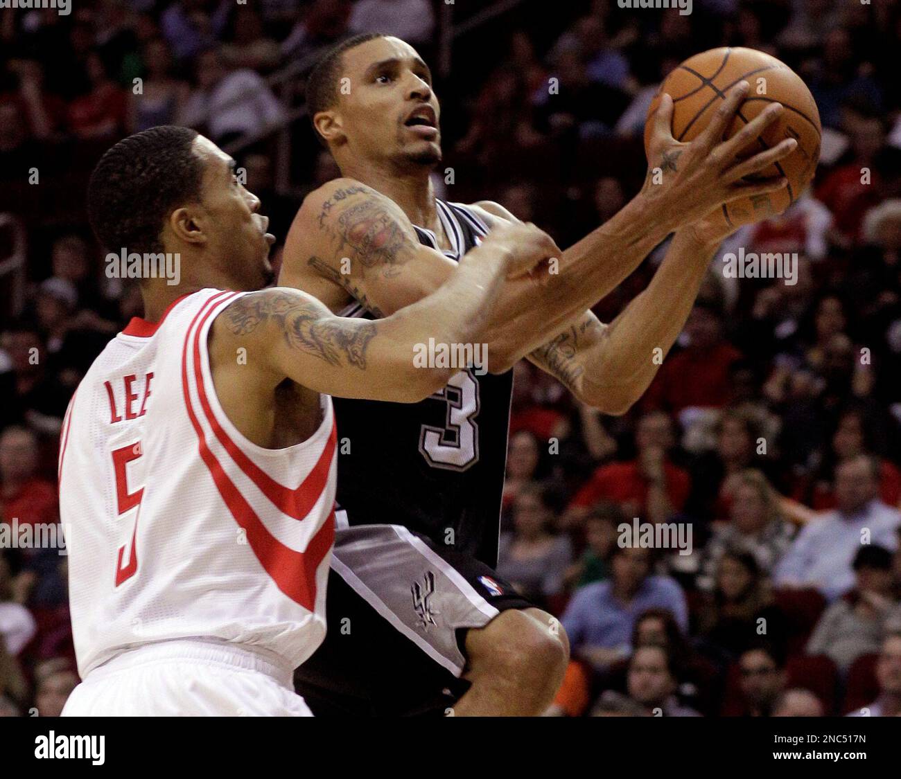 Houston Rockets' Courtney Lee (5) tries to stop San Antonio Spurs' George Hill (3) from scoring during the first half of an NBA basketball game on Saturday, March 12, 2011, in Houston. (AP Photo/Pat Sullivan) Banque D'Images