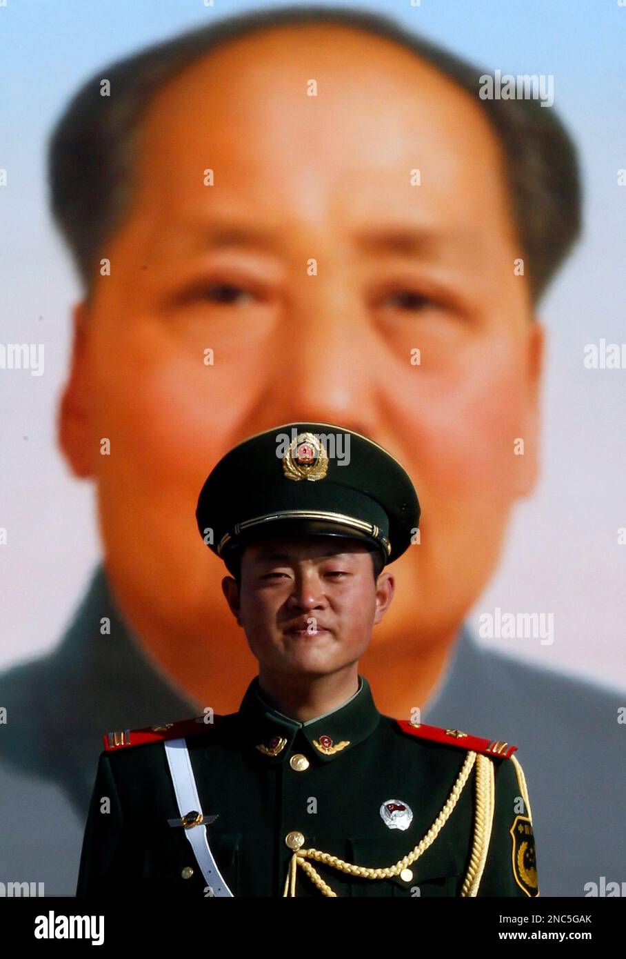 A Chinese paramilitary police man stands on duty in front of a portrait of Mao Zedong during a session of the National People's Congress held in the Great Hall of the People in Beijing, China, Thursday, March 10, 2011. China will never adopt multiparty democracy or other Western-style political reforms that could challenge the Communist Party's grip on power, the head of the country's national legislature said Thursday. (AP Photo/Ng Han Guan) Banque D'Images