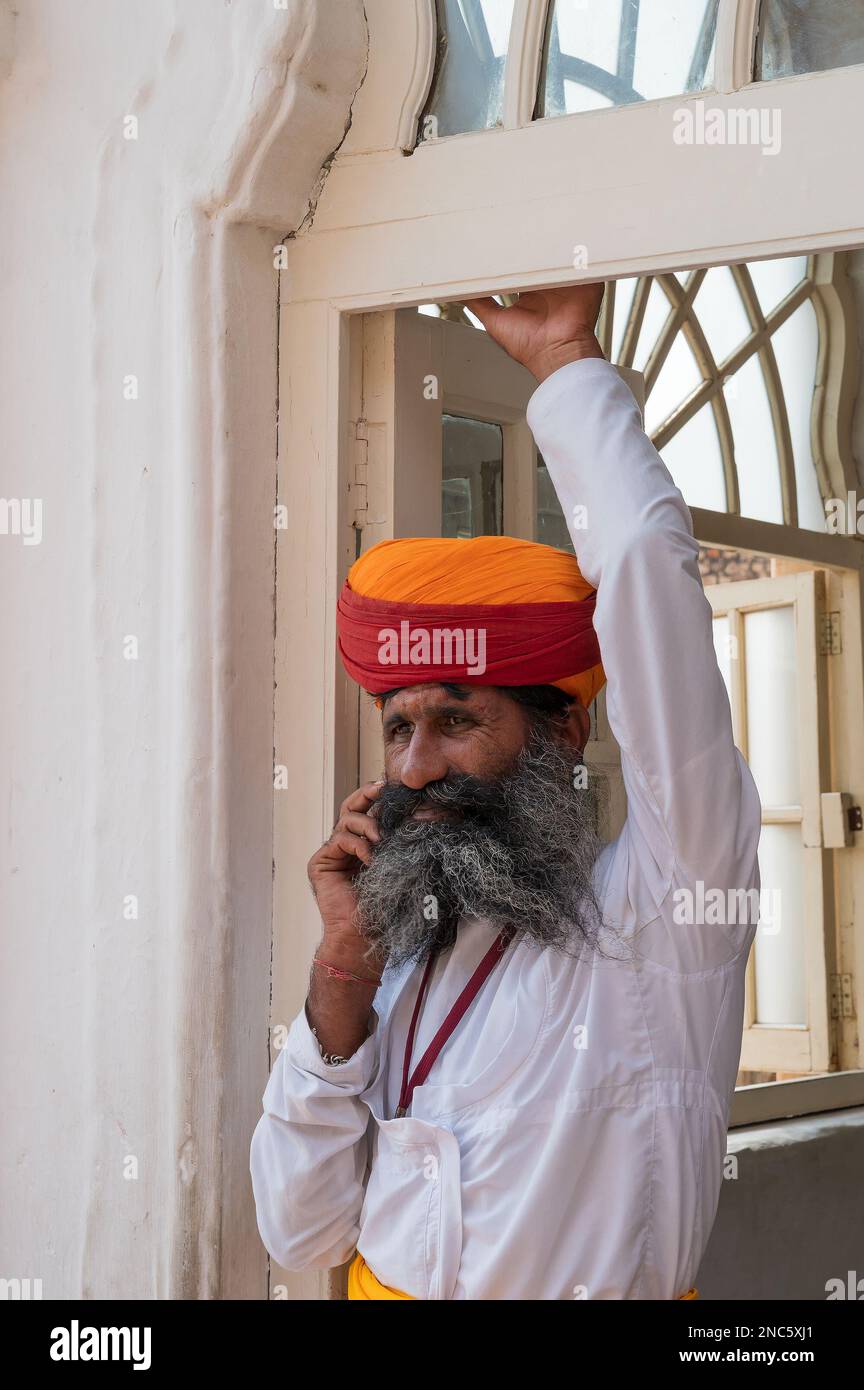 Jodhpur, Rajasthan, Inde - 19 octobre 2019 : Rajput homme senior avec turban coloré appelé pagri, parlant sur son téléphone mobile de nouvelle technologie. Banque D'Images