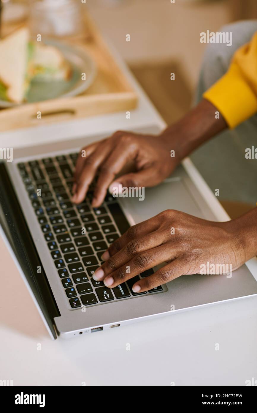 Image en gros plan d'une jeune femme qui tape sur un ordinateur portable lorsqu'elle travaille au bureau à domicile Banque D'Images