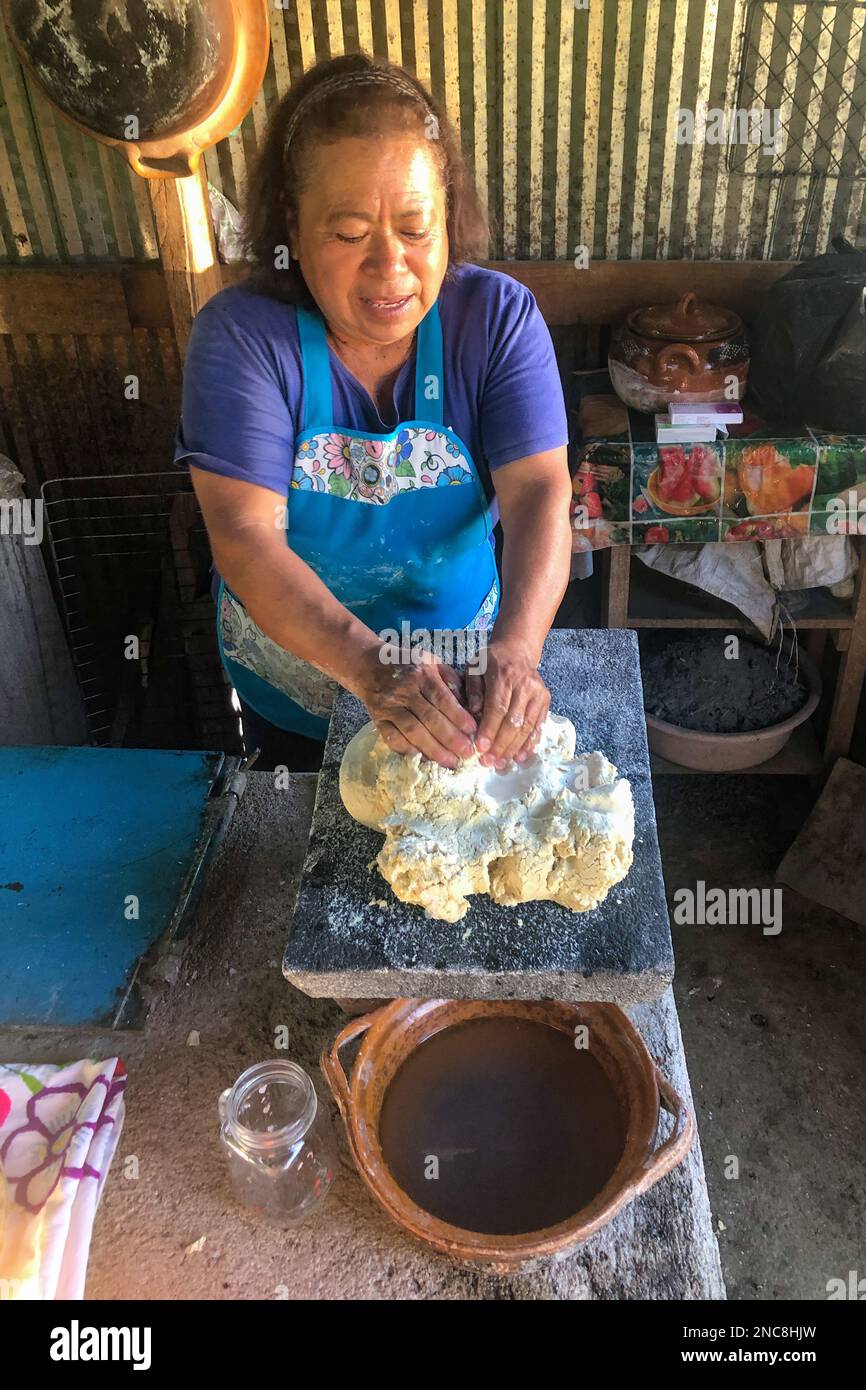 Une femme pétrit la pâte de masa de maïs pour faire des tortillas de maïs traditionnels dans une cuisine extérieure dans la campagne d'Oaxaca, au Mexique. Les tortillas sont une agrafe dans le Mexica Banque D'Images