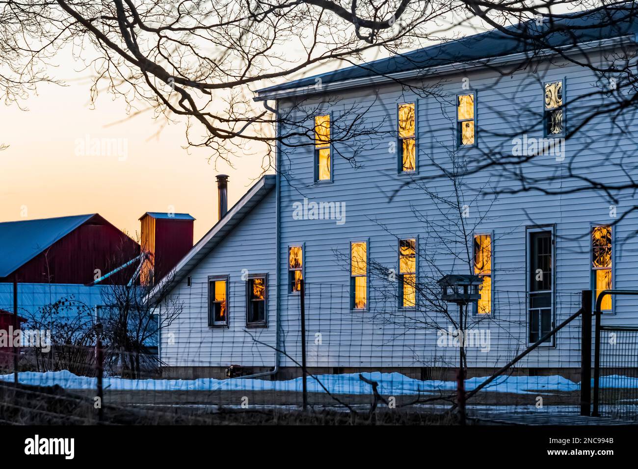 Les fenêtres de la ferme Amish reflètent le coucher du soleil dans le comté de Mecosta, Michigan, États-Unis [aucune autorisation de propriété ; licence éditoriale uniquement] Banque D'Images