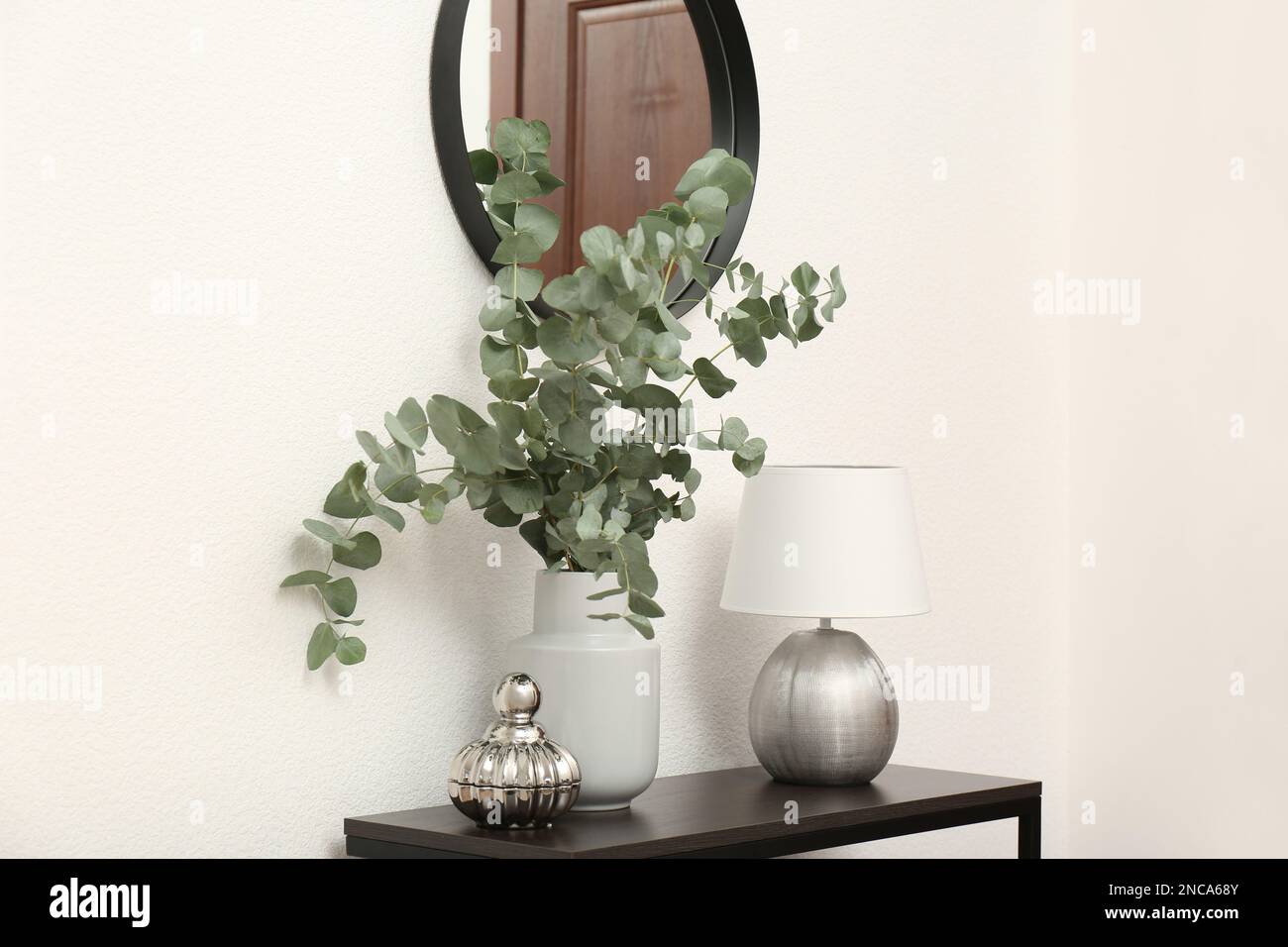 Table de console moderne, décoration élégante, miroir sur mur blanc dans la chambre. Design intérieur Banque D'Images