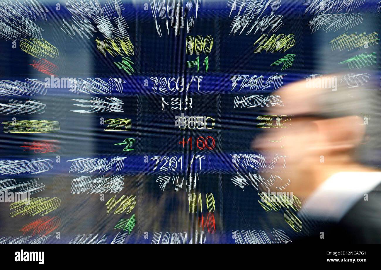A man walks past an electronic board showing the stock price of Toyota Motor Corp., center, in Tokyo, Japan, Wednesday, Feb. 9, 2011. Toyota Motor Corp. stock finished the morning session at 3,650 yen ($44) on the Tokyo Stock Exchange, the highest since its close on May 13, buoyed by the results of the 10-month investigation. Overnight on Wall Street, Toyota gained by more than 4 percent to close at $88.57. (AP Photo/Shizuo Kambayashi) Banque D'Images