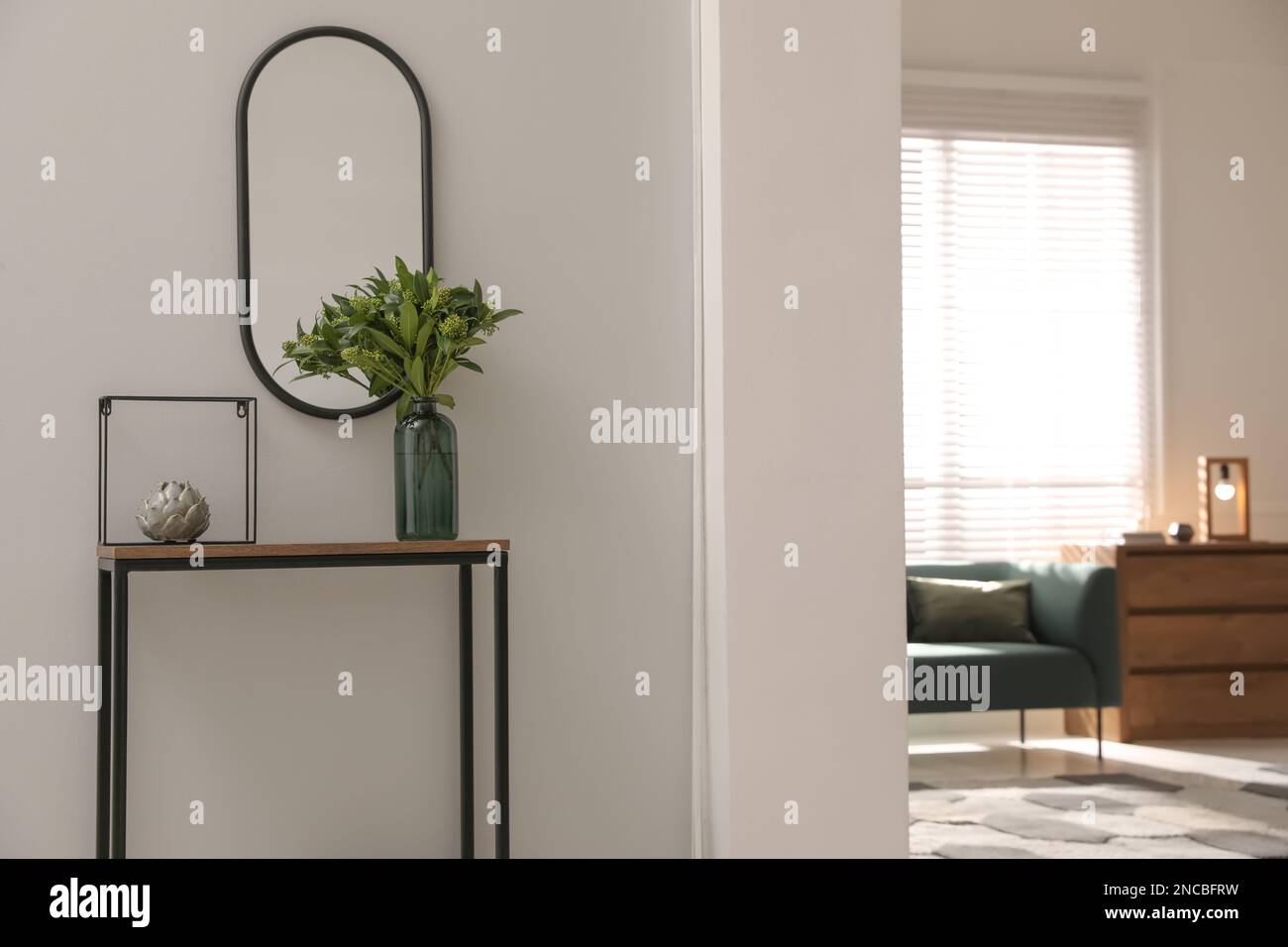 Table de console avec décoration et miroir sur le mur lumineux dans le couloir. Design intérieur Banque D'Images