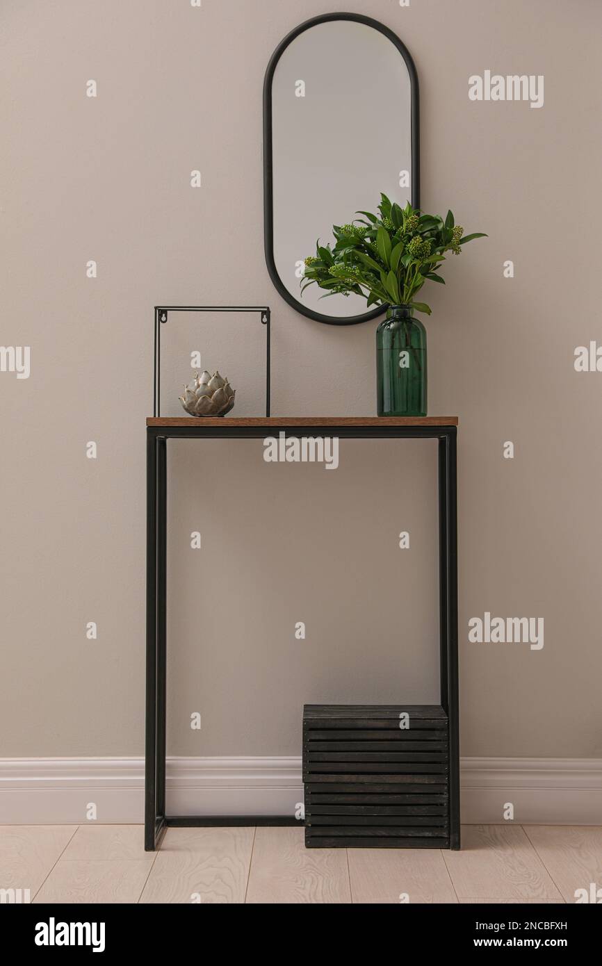 Table de console avec décoration et miroir sur le mur lumineux dans le couloir. Design intérieur Banque D'Images