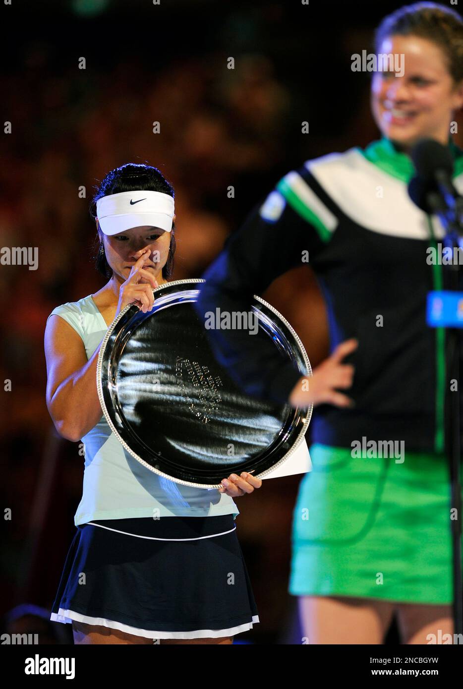 Runner-up China's Li Na, left, reacts, as Kim Clijsters of Belgium delivers speech after Clijsters won their women's singles final at the Australian Open tennis championships in Melbourne, Australia, Saturday, Jan. 29, 2011. (AP Photo/Andrew Brownbill) Banque D'Images