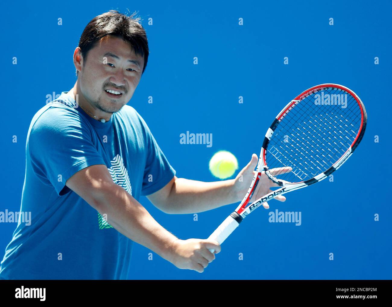 Coach and husband of China's Li Na, Jiang Shan, hits the ball to Li on an outside court at the Australian Open tennis championships in Melbourne, Australia, Friday, Jan. 28, 2011. Li will play Belgium's Kim Clijsters in the women's final here Saturday Jan 29. (AP Photo/Vincent Thian) Banque D'Images
