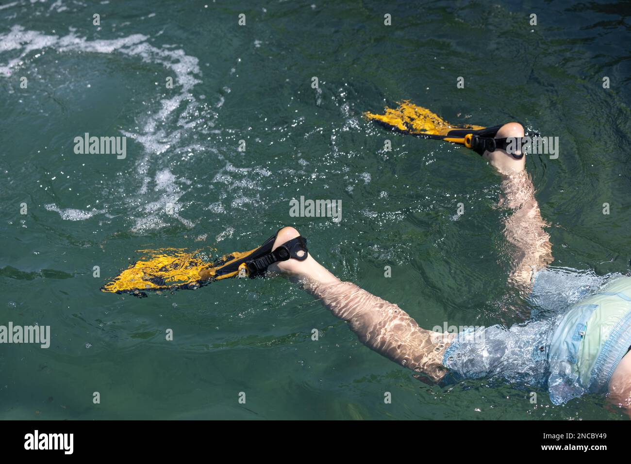 Photo en gros plan d'un enfant portant des palmes pendant la plongée en apnée dans l'océan Banque D'Images