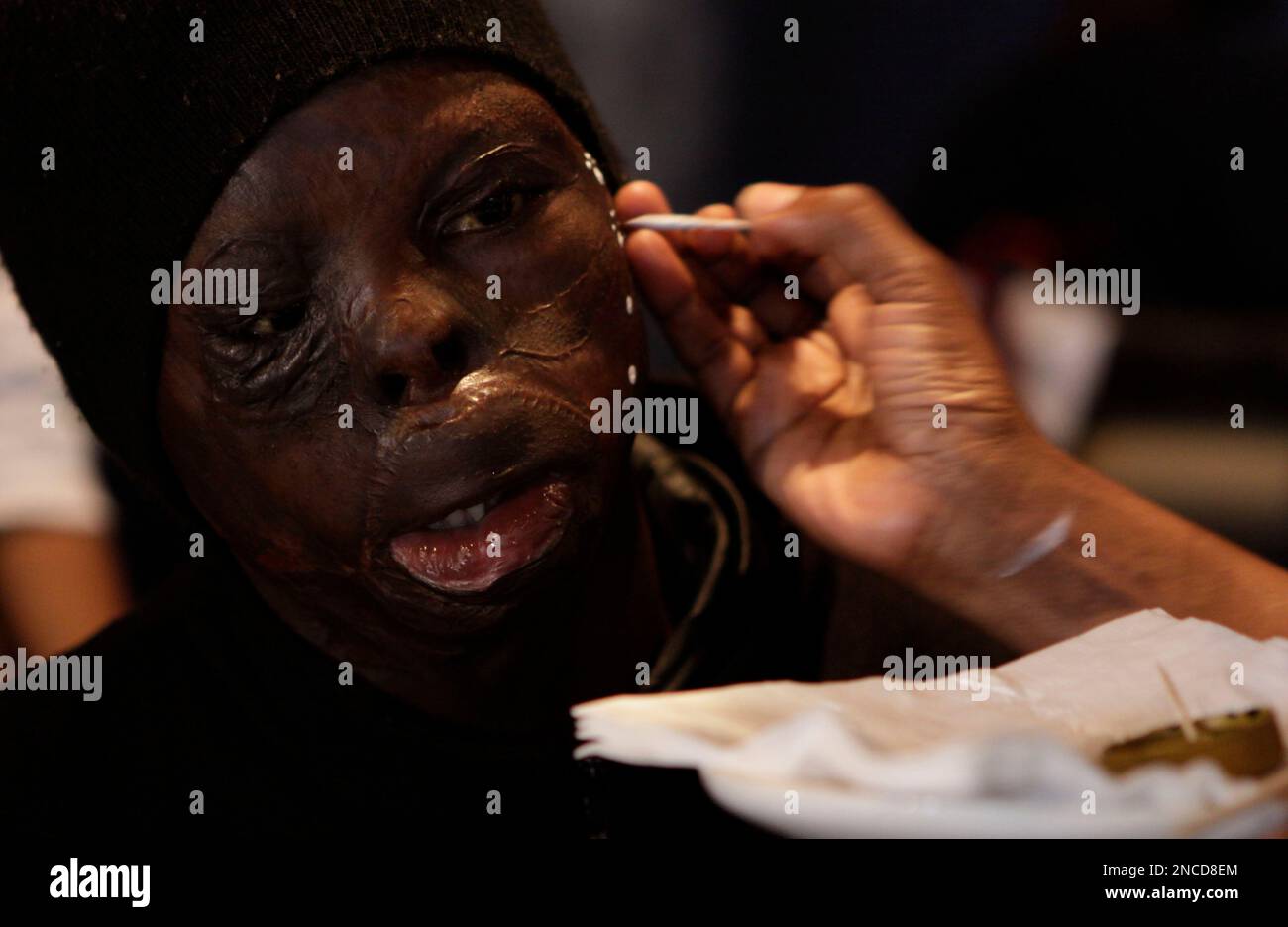A child has his face painted as Children of Fire survivors attend a victory lunch in Johannesburg, Sunday, Jan. 16, 2010 after their return from climbing Mount Cameroon. The charity organised the exhibition to boost the confidence and inspire hope in survivors of fire accidents, many of whom have been abandoned by their families. The exercise also taught the children the geography, culture religion and history of the region. (AP Photo/Denis Farrell) Banque D'Images