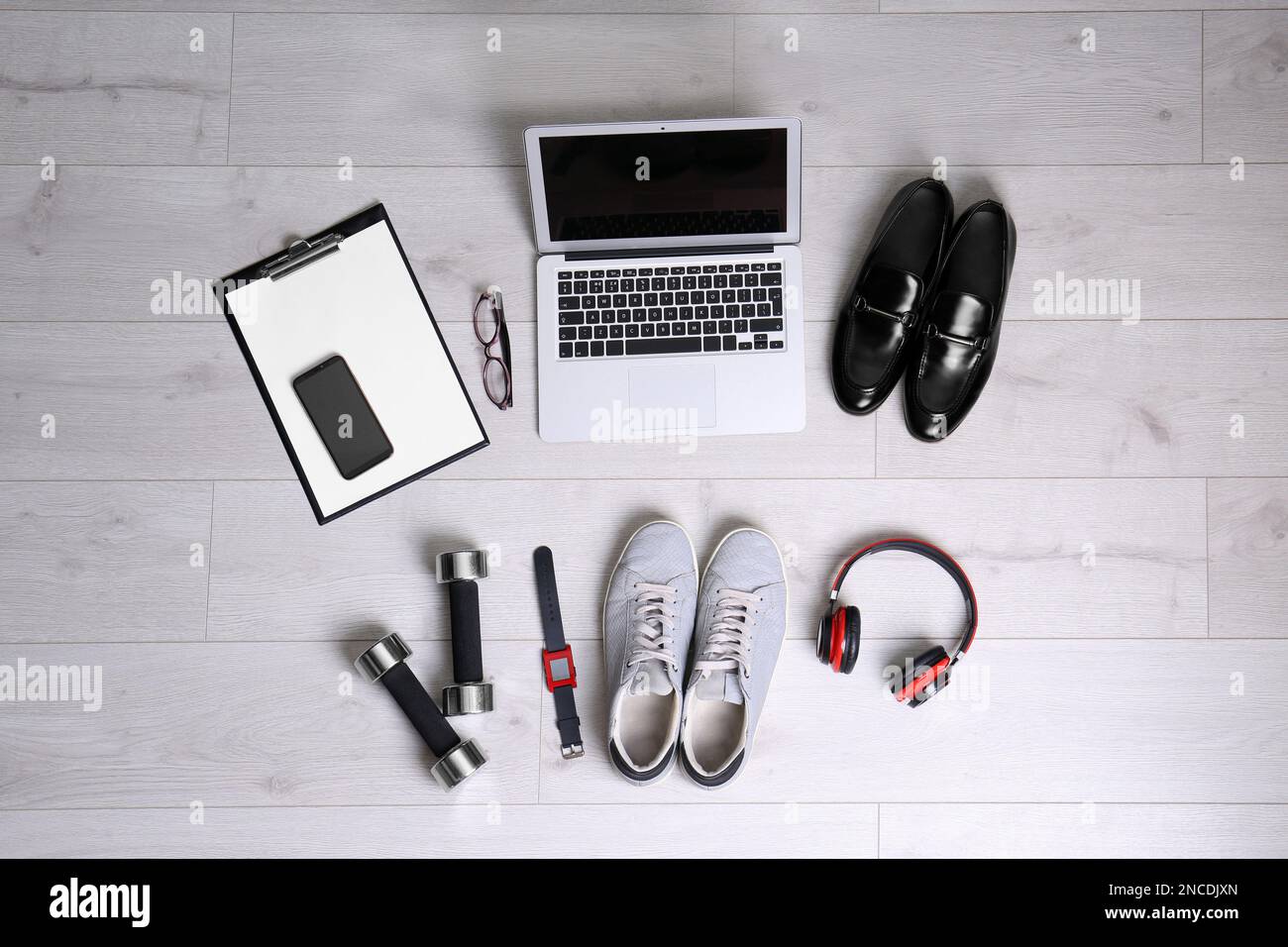 Composition à plat d'articles professionnels avec accessoires de sport sur fond blanc en bois. Concept d'équilibre vie-travail Banque D'Images