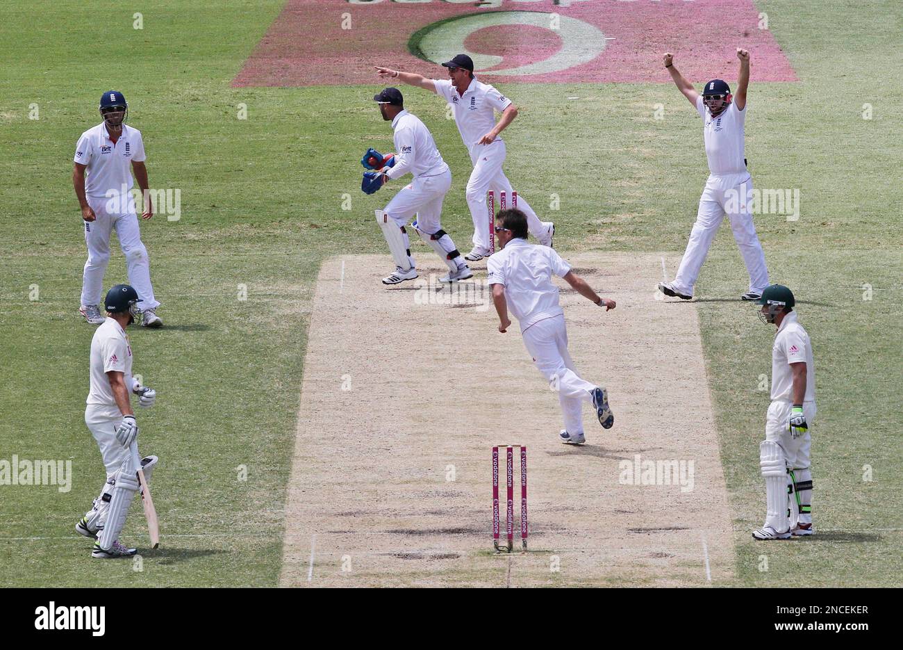 As both Australian batsman Shane Watson, left, and Phil Hughes, right, stand at the same end of the pitch, England celebrate a run out on the fourth day of the fifth and final Ashes cricket test at the Sydney Cricket Ground in Sydney, Australia, Thursday, Jan. 6, 2011. (AP Photo/Rob Griffith) Banque D'Images