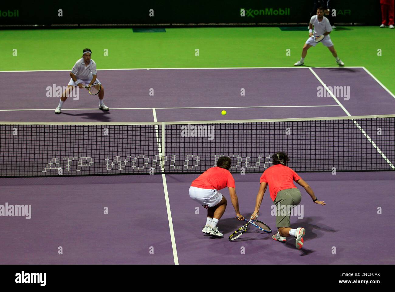 Marc Lopez of Spain, foreground left, and team member world number one tennis player Rafael Nadal, foreground right, return the ball to Pere Riba of Spain, background left, and Spain's David Marrero, background right, during the Qatar ATP Open Tennis tournament in Doha, Qatar, Monday, Jan. 3, 2011. (AP Photo/Hassan Ammar) Banque D'Images