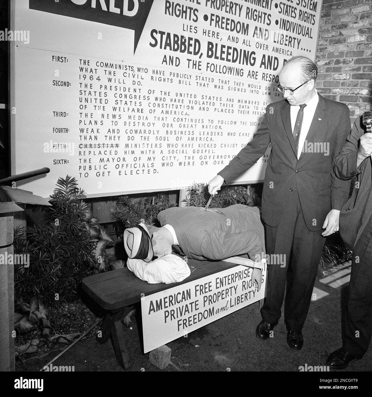 Lester Maddox puts a knife in the back of a life size manikin after he opened his restaurant in Atlanta, August 11, 1964. Maddox, under federal court order to serve blacks, said his action represents what has happened to the American free enterprise system. “It has been stabbed in the back,” Maddox said as he refused again to comply with the court order. (AP Photo) Banque D'Images