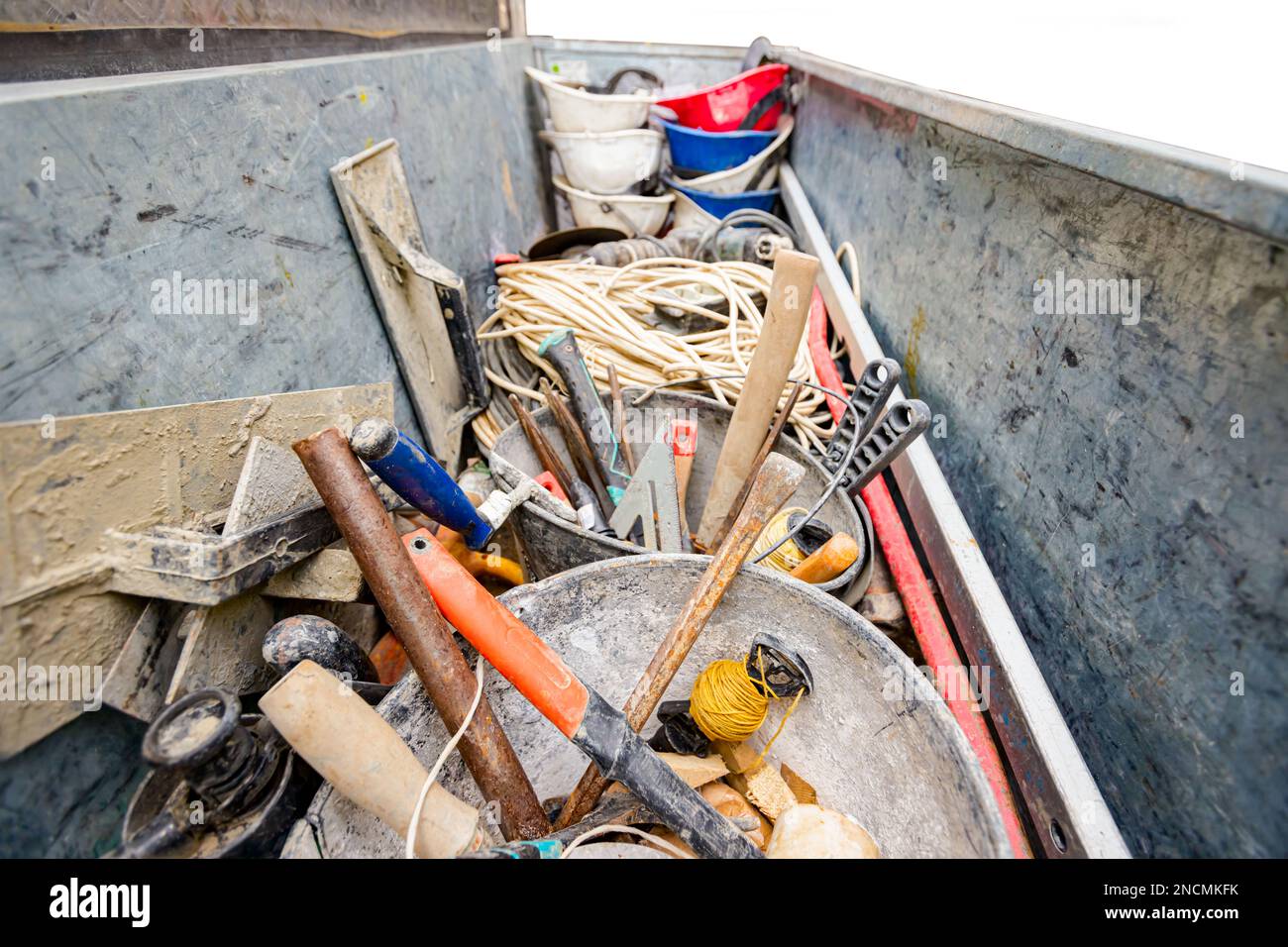 Une caisse en acier, un conteneur et une boîte à outils en trop de nombreux outils différents ont été placés dans la remorque du camion sur le chantier. Banque D'Images