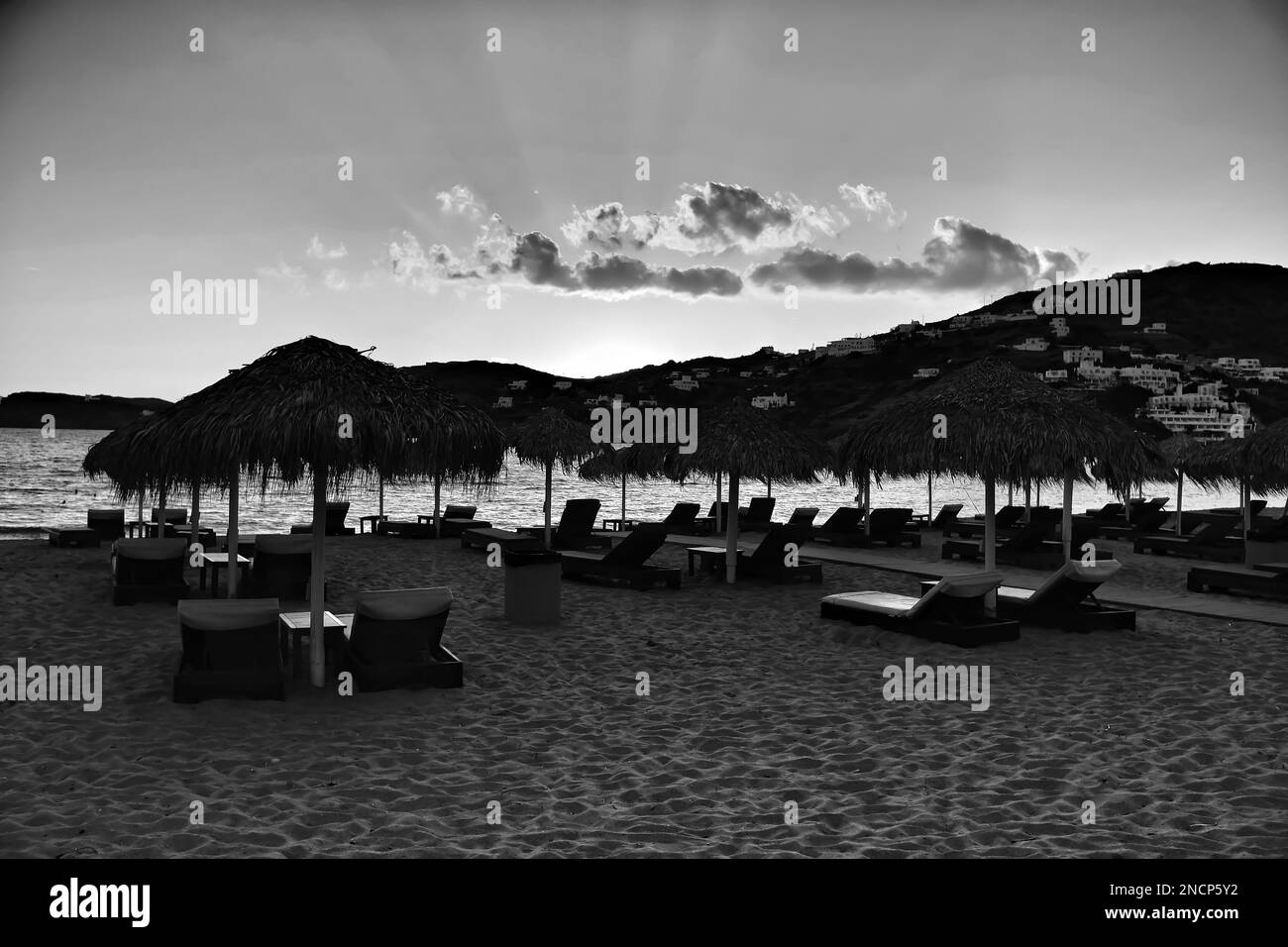 Vue sur les chaises longues vides et un beau coucher de soleil sur la plage de Mylopotas dans iOS Grèce Banque D'Images