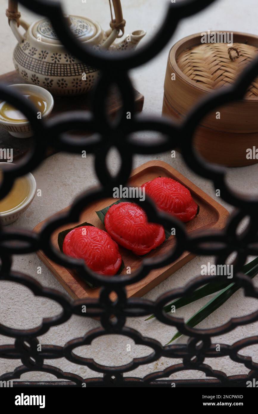 gâteau cuit à la vapeur avec garniture de haricots mung servi avec une tasse de thé vert vu de derrière des barres de fer Banque D'Images