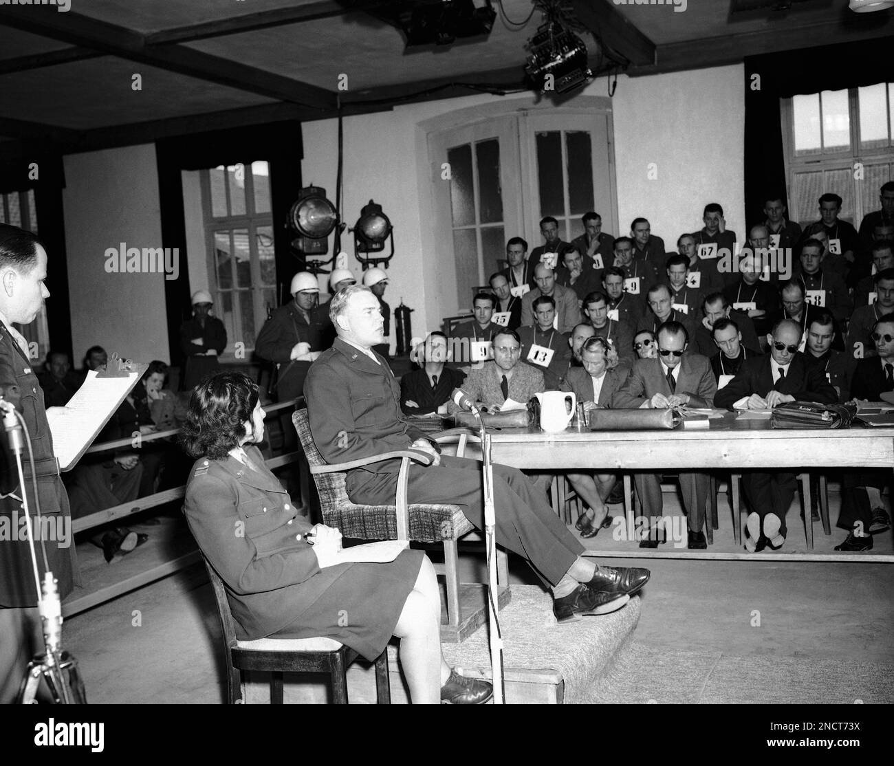 Homar Ford, of Leeton, Missouri tells the War Crimes Court at Dachau, Germany, how he and his comrades were shot down by Nazi SS troops at Malmedy during the Battle of the Bulge, May 22, 1946. Ford and other survivors of the massacre testified at the trial of 74 SS troopers, some of whom are in the background, who are accused of the crime. (AP Photo) Banque D'Images