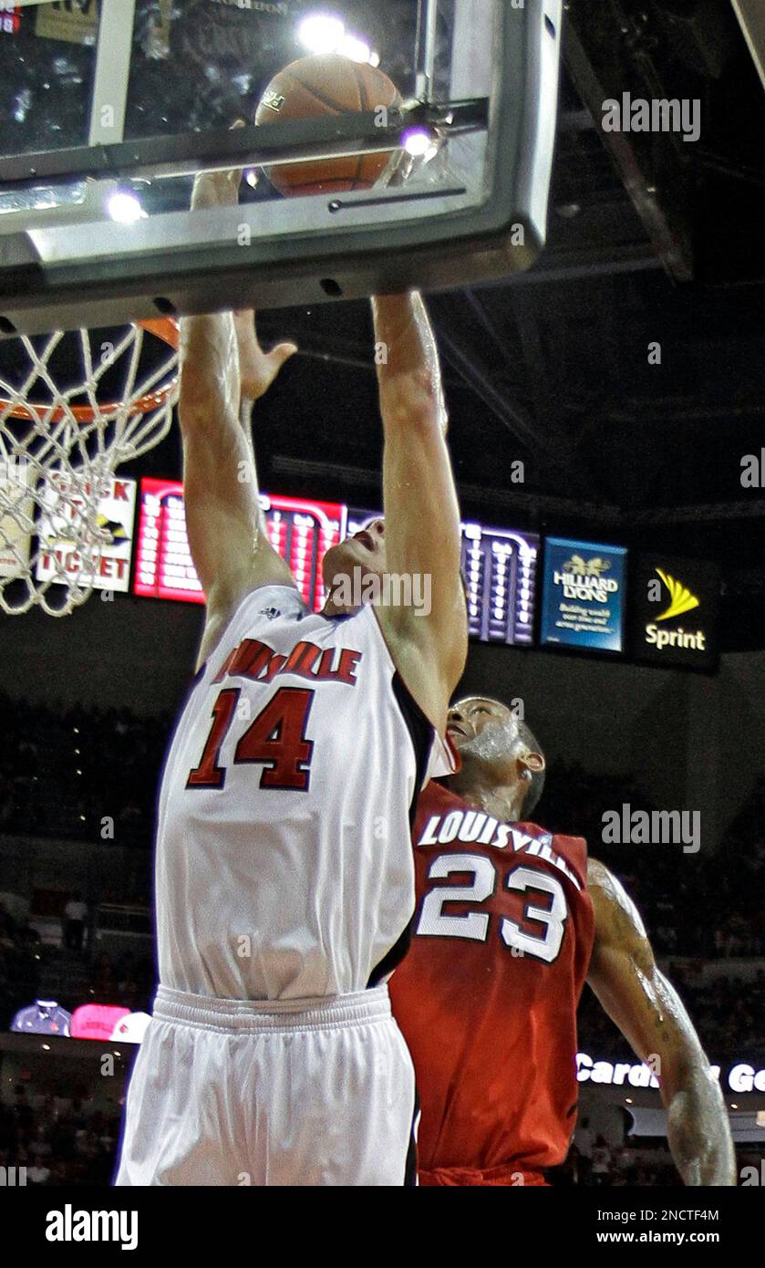 Louisville's Kyle Kuric (14) gets inside against teammate Terrence Jennings (23) to score during action in the Red-White NCAA college basketball public scrimmage at the KFC Yum! Center arena in Louisville, Ky., Sunday, Oct. 24, 2010. (AP Photo/Garry Jones) Banque D'Images