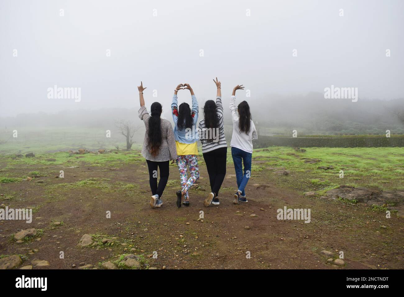 MAHAARRSHTRA, PUNE, LONAVALA, août 2022, Groupe de jeunes filles indiennes en couleur-ensembles décontractés appréciant la nature, face à l'arrière montrant main si Banque D'Images