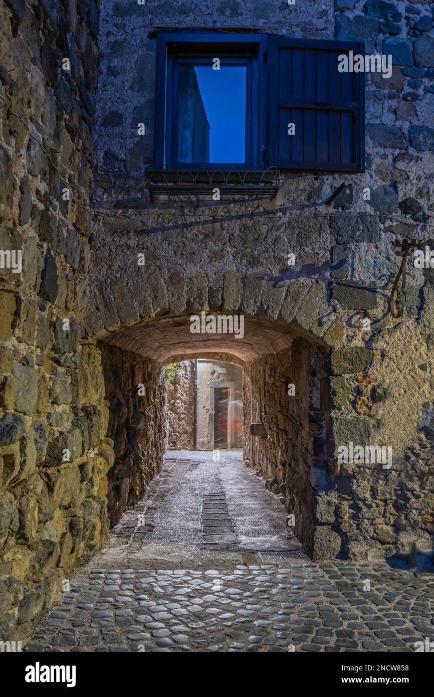 Aperçu nocturne des ruelles, des palais, des arches et des escaliers du village médiéval en pierre et en brique de la municipalité de Bolsena. Bolsena, Latium Banque D'Images